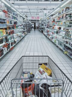 A shopping trolley down the aisle of a supermarket