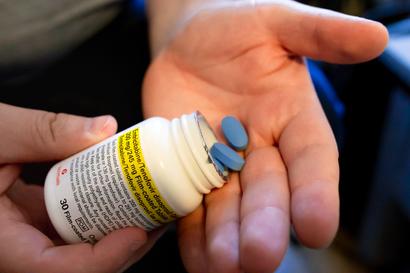 PrEP pills being dispensed into a hand