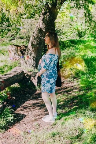 A pregnant women standing in a forrest